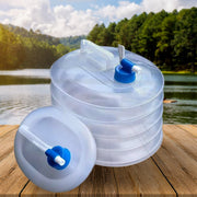 A translucent collapsible water container with a blue spigot sits next to its collapsed form on a wooden surface by – view 4