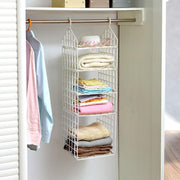 White 5-layer plastic hanging closet organizer with folded clothes and a hat in a white closet.