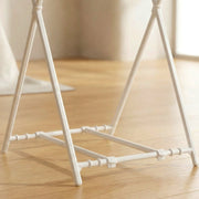 Close-up view of the white plastic base and connecting pieces of the bag holder on wood flooring.