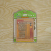 A 32-in-1 precision screwdriver set in its clear retail packaging with green and orange accents, on a wooden surface.