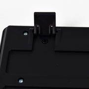 A close-up of the back of a black keyboard showing an extended kickstand and screws.