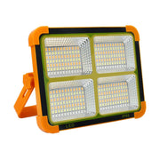Orange and black solar LED flood light with four bright white LED panels and a black frame, on a white background.