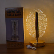 A feather-shaped crystal table lamp next to its product box, which displays a different lamp design.