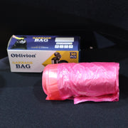 A roll of pink garbage bags next to a white box labeled 