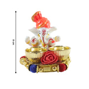 A white Ganesha idol with an orange turban on a gold base with two empty gold bowls and a red rose, with an 8 cm height