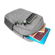 A grey backpack with sunglasses, a notebook, and a blue laptop partially visible from an open compartment.