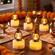 Six glowing golden lantern LED candles are placed on embroidered fabric runners, surrounded by marigold garlands and