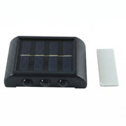 A black solar-powered LED wall light with a solar panel and three sensors, next to a white adhesive strip on a white