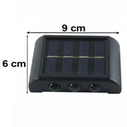 A black solar-powered LED wall light with dimensions of 9 cm width and 6 cm height displayed on a white background.