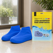 Two blue latex shoe covers next to a yellow and blue package for 