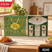 A green and gold gift box with an open box revealing a white ceramic snack and tea set, with a red 