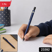 A child's hand writes with a blue mechanical pencil on lined paper, with a smaller inset image of the pencil on a – view 2