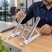 Man adjusting the height of a white and gray laptop stand on a wooden desk in an office.