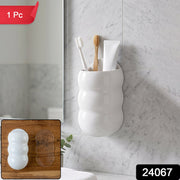 White, caterpillar-shaped wall holder with toothbrushes and toothpaste, with a red 