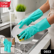 A person wearing teal rubber gloves washes a white plate under running water in a kitchen sink, with a small inset showing