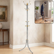 A tall, silver-colored metal clothes hanger stand with gold accents and multiple hooks stands in a room with a painting and