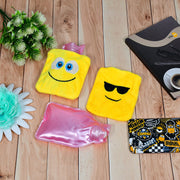 Two yellow emoji hot water bags and one pink plastic hot water bottle are on a light wood surface.