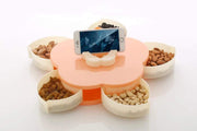 A teal and black petal-shaped storage box is open, revealing its compartments, with a