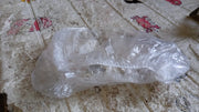 Disposable clear plastic shower caps displayed in a stack.