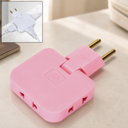 A pink 3-in-1 foldable wall plug adapter with brass pins, shown on a light marble surface. Inset shows a white version with