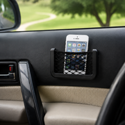 A black mesh car organizer holding a white smartphone, attached to a car door panel.