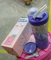 Portable smoothie maker powered on, with its stainless steel blades visible and ready for use.