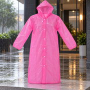 A pink translucent rain coat with a hood and white snap buttons hangs outdoors in the rain.