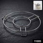 A shiny silver wire hot pot stand rests on a dark slate surface, with a small inset of a pot on the stand.