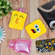 Two yellow emoji hot water bags and one pink plastic hot water bottle are on a light wooden surface.