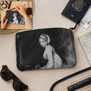 A black and white travel pouch featuring a classic painting of a woman, surrounded by travel essentials.