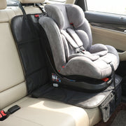 A gray child's car seat is positioned on a black protector in a beige car interior.