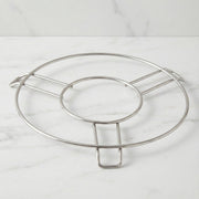 A silver wire hot pot stand is centered on a light grey marble countertop.