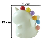 A cream-colored unicorn-shaped stand with five colorful ball-tipped fruit forks, showing dimensions of 13 cm height and 9 cm