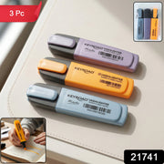 Three Keyroad Metallic highlighters in light blue, orange, and purple, with a person highlighting text in the bottom left