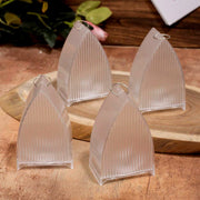 Four unlit transparent arch stripe LED candles with silver rings on top, arranged on a wooden surface with a blurred