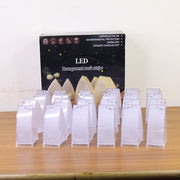 Eighteen unlit transparent arch stripe LED candles in front of their product box, all on a light wooden surface.