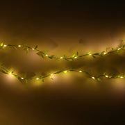 Two horizontal strands of green leaf string lights with small, warm white LEDs against a dark background.