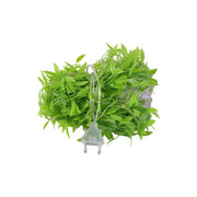 A coiled bundle of bright green artificial leaves with an attached clear electrical plug, on a white background.