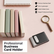A black leather and steel business card holder with a magnifying glass and small books on a pink surface, with text