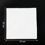 A single white paper napkin on a black surface, showing its 27 cm by 27 cm dimensions.
