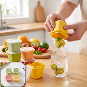 A person dispenses a citrus-infused ice cube from a yellow mold into a glass of water on a wooden counter, surrounded by