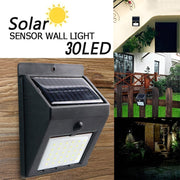 Black solar-powered wall light with 30 LEDs on a wooden wall, with insets showing it installed on various outdoor walls.