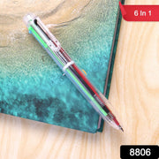 A clear 6-in-1 multicolor ballpoint pen with various ink colors is on a teal and brown surface, with a 
