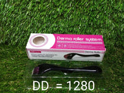 A derma roller in a clear plastic tray and its pink and white box are displayed on artificial grass.
