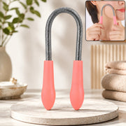 A pink and silver facial hair remover spring tool stands upright on a light stone surface, with a small inset showing it