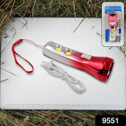 A red and silver torchlight, USB cable, and retail packaging are displayed on a laptop in grass.