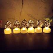 Six golden leaf LED candles glowing in a row on a dark surface against a textured background.