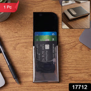 A black leather and steel business card holder on a wooden desk with credit cards inside, with a red 1 Pc sticker and a