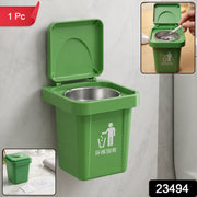 A green mini trash can ashtray with an open lid, wall-mounted, with inset images showing a hand with a cigarette and the
