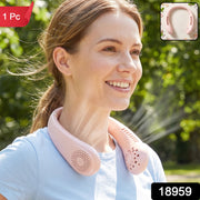 A woman smiles wearing a pink portable neck fan outdoors, with a 